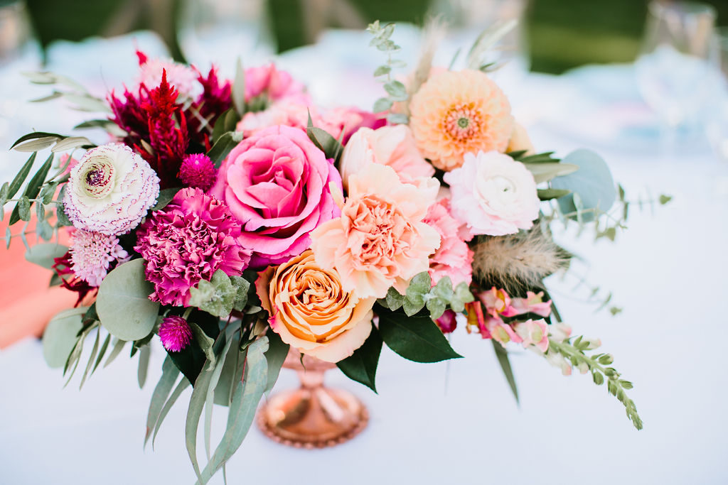bright pink and orange wedding reception centerpiece in rose gold vase at Triunfo Creek Vineyards