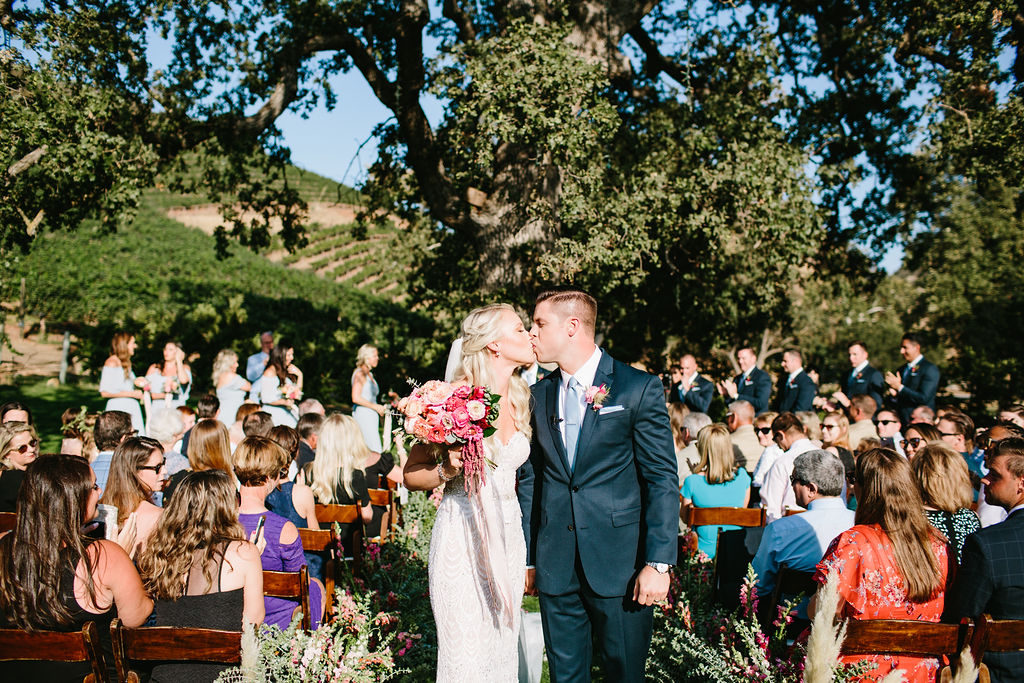 bride and groom kiss during wedding ceremony at Triunfo Creek Vineyards