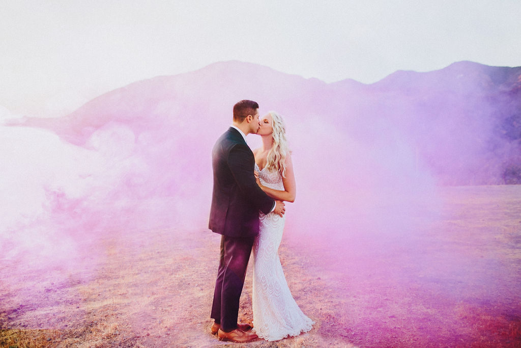 bride and groom sunset wedding portrait shot with smoke bombs at Triunfo Creek Vineyards, adding a pop of color to your big day