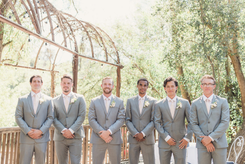 An emotional calamigos ranch wedding, groomsmen in light grey suits and pale pink ties