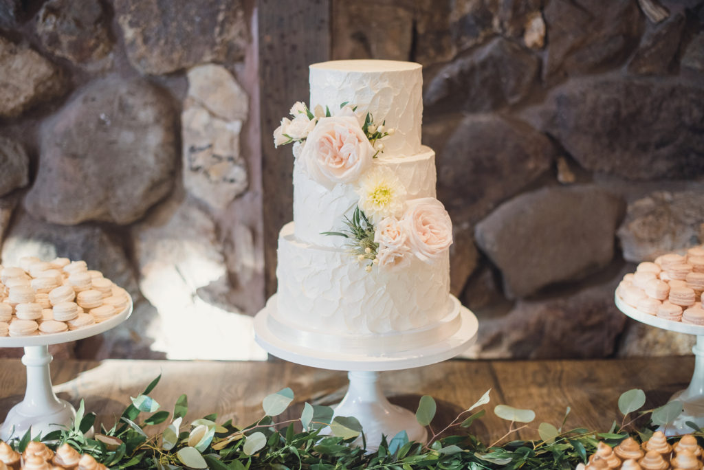 An emotional calamigos ranch wedding, reception tables, three tier cake with pink flowers