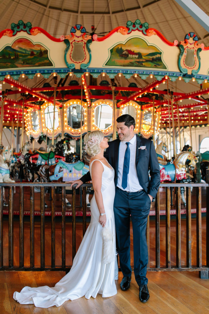 A glam and California infused wedding at Viceroy Santa Monica, bride and groom portrait shot in front of carousel on Santa Monica pier