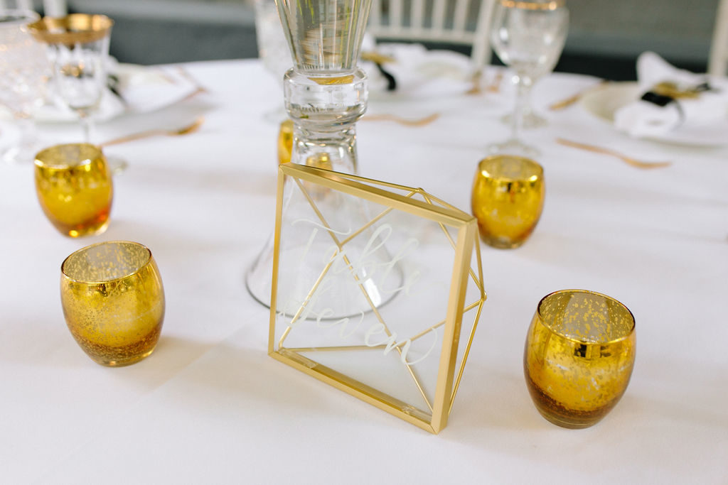 A glam and California infused wedding reception table with gold table number at Viceroy Santa Monica