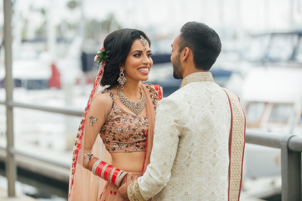 Stunning Indian Wedding in San Pedro, bride in gold and red wedding sari and groom in gold sherwani, bride and groom first look