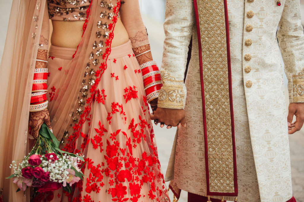 Stunning Indian Wedding in San Pedro, bride in gold and red wedding sari and groom in gold sherwani, bride and groom portrait shot