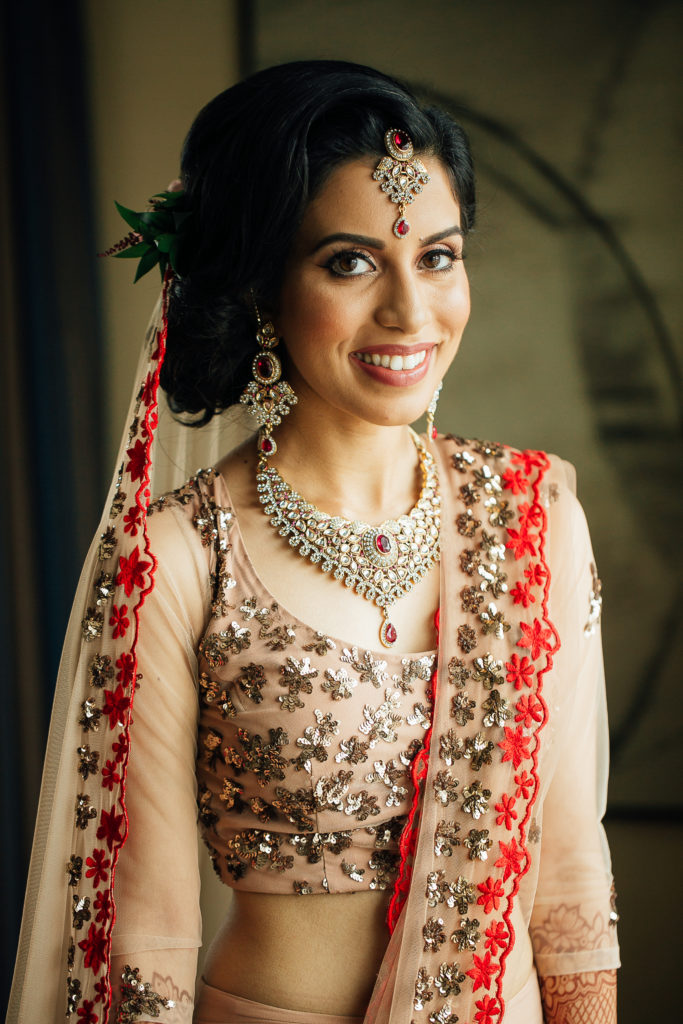 Stunning Indian Wedding in San Pedro, bride in gold and red wedding sari getting ready, bridal hair and makeup