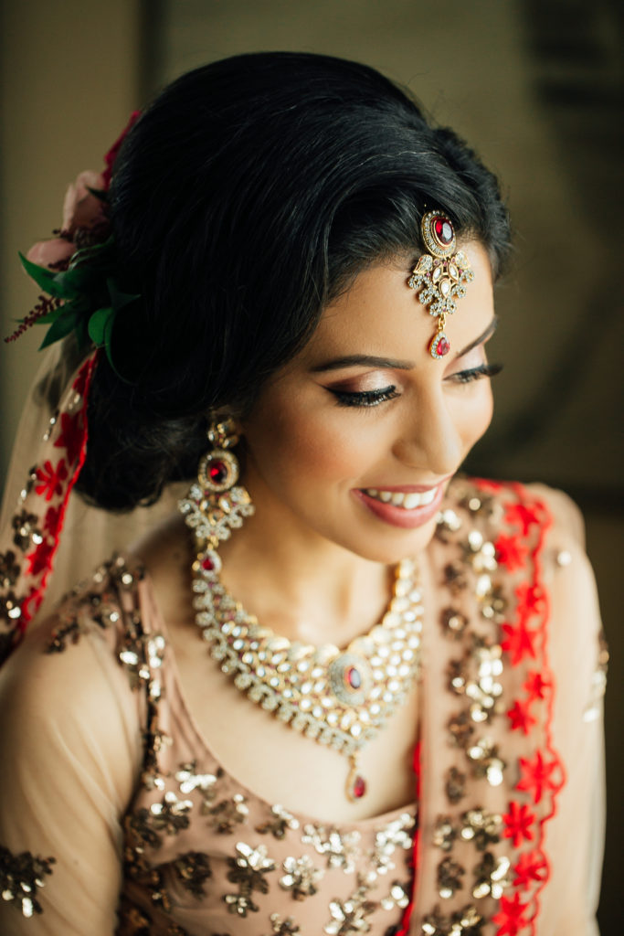 Stunning Indian Wedding in San Pedro, bride in gold and red wedding sari getting ready, bridal hair and make up