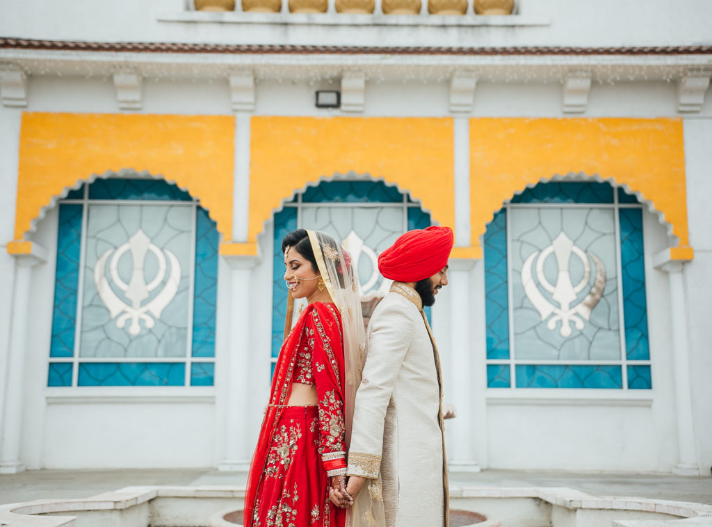 Stunning Indian Wedding in San Pedro, red bridal sari and groom in gold sherwani for sikh ceremony, bride and groom first look
