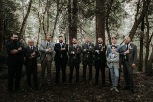 Summer camp themed wedding in Big Bear at Camp Wasegan, groom and groomsmen with axe wedding party gifts