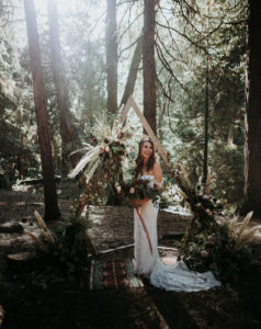 Summer camp themed wedding in Big Bear at Camp Wasegan, bridal portrait shot in the forest with king protea bridal bouquet