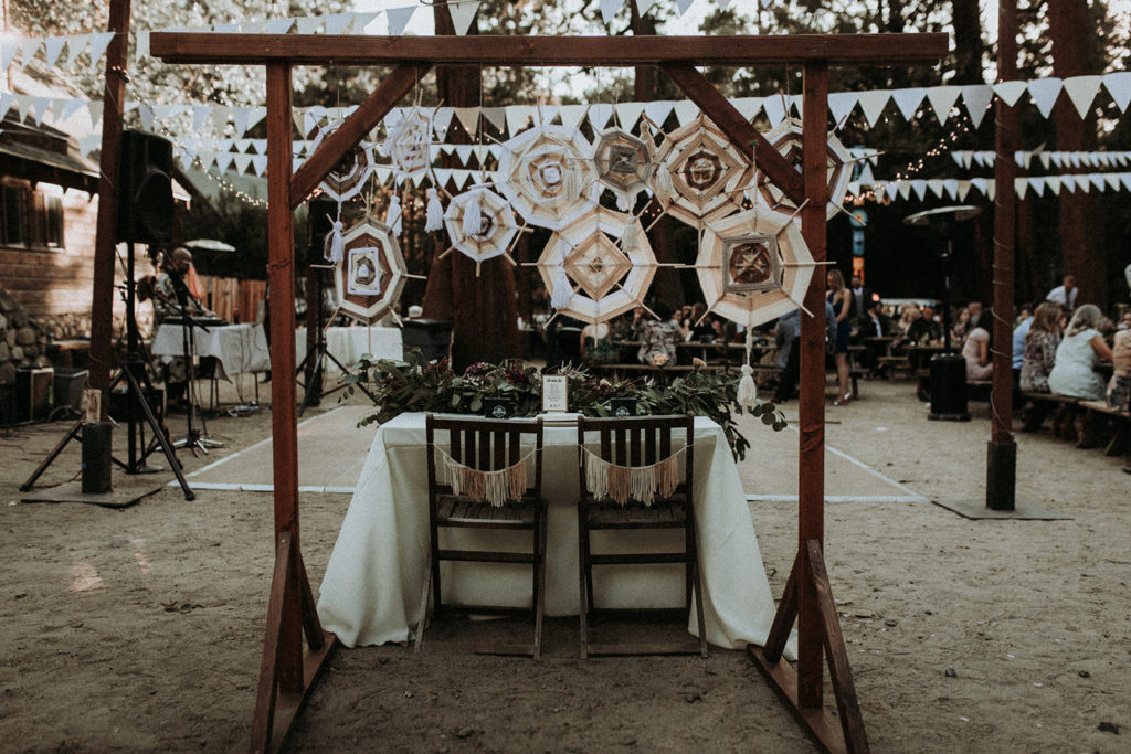 Summer camp themed wedding reception in Big Bear at Camp Wasegan, bohemian sweetheart table with dream catchers