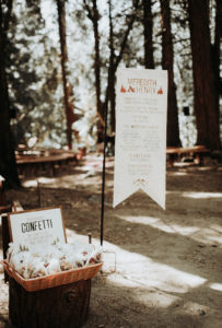 Summer camp themed wedding in Big Bear at Camp Wasegan, wedding welcome sign with bio degradable confetti