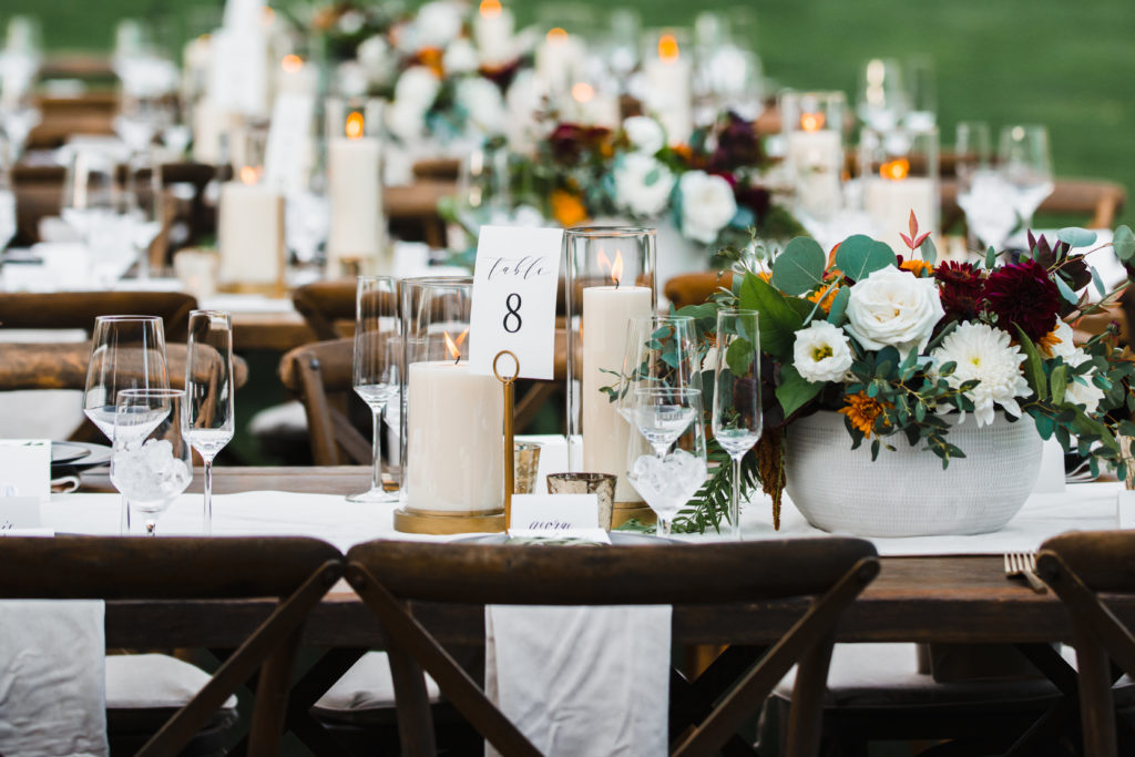 A simple and modern wedding reception at Triunfo Creek Vineyards, tall pillar candles with low floral arrangements