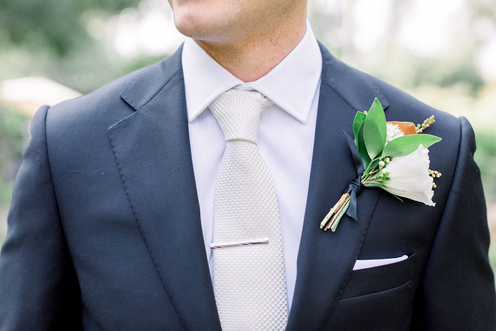 A Romantic Fall Wedding at Maravilla Gardens, groom with silver tie and magnolia leaf boutonniere