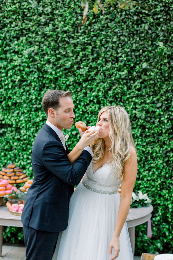 A Romantic Fall Wedding reception at Maravilla Gardens, bride and groom eating donut