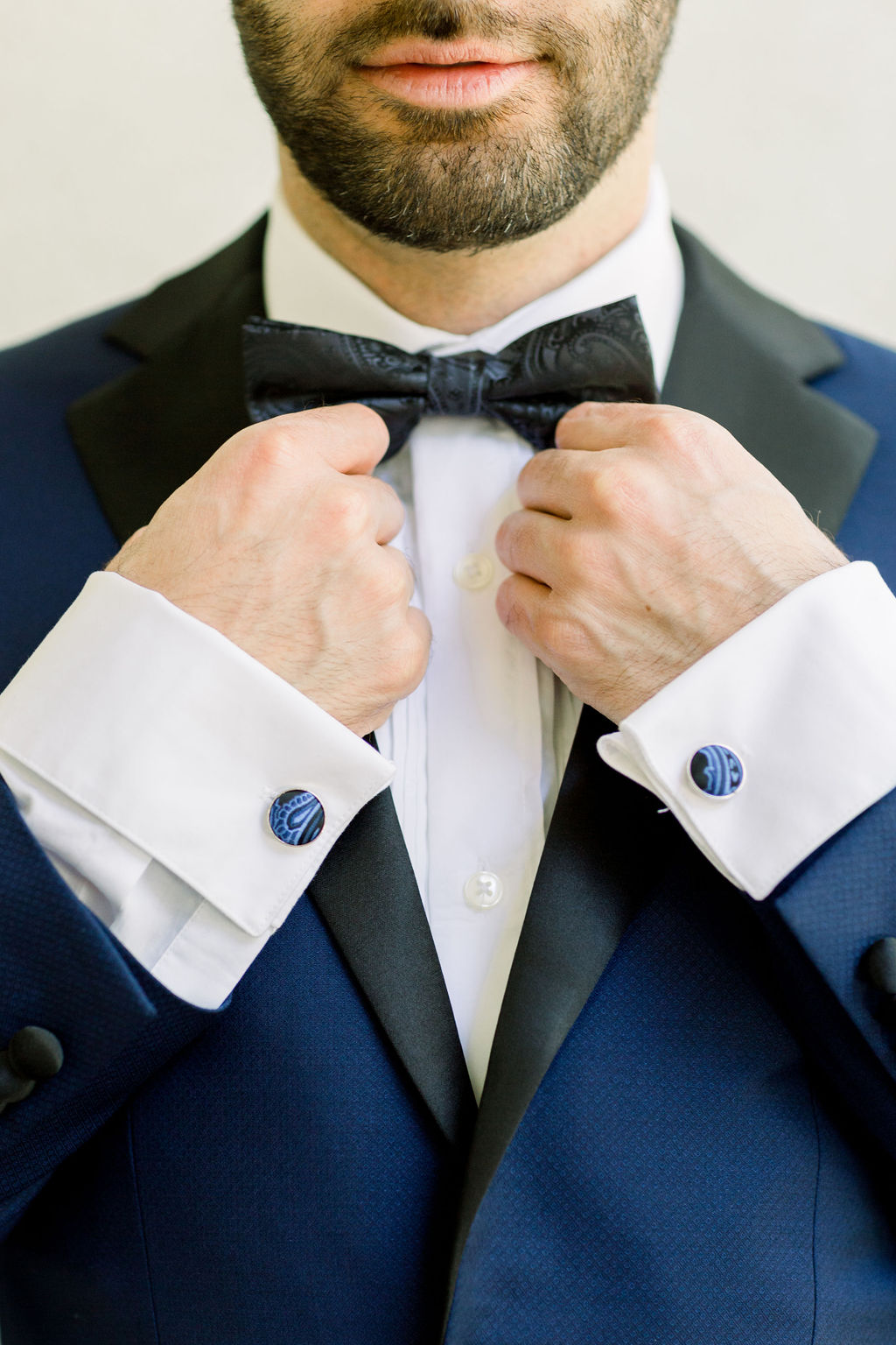 groom with paisley detail bowtie and blue tuxedo