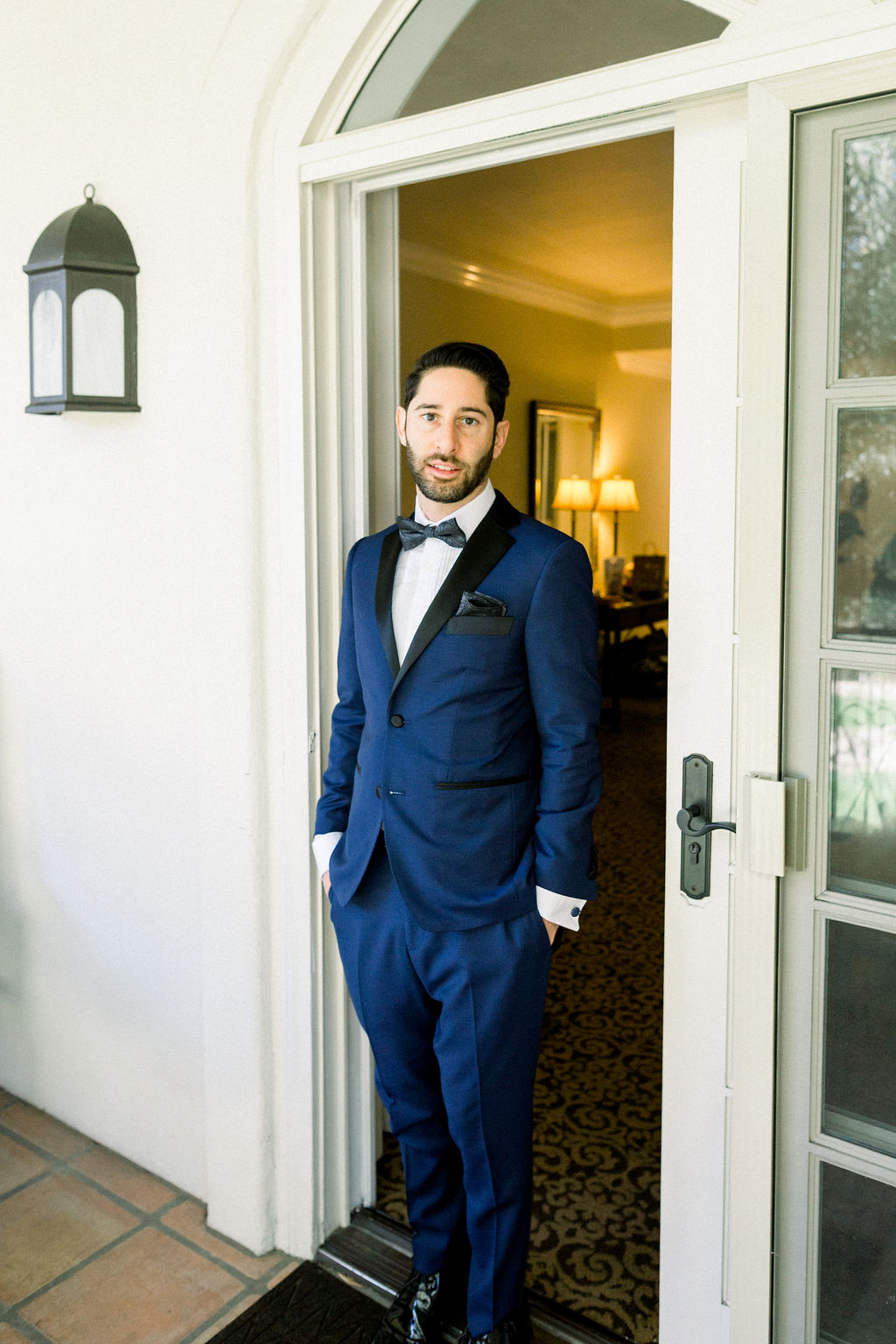 groom in blue tuxedo suit with paisley detail bowtie 