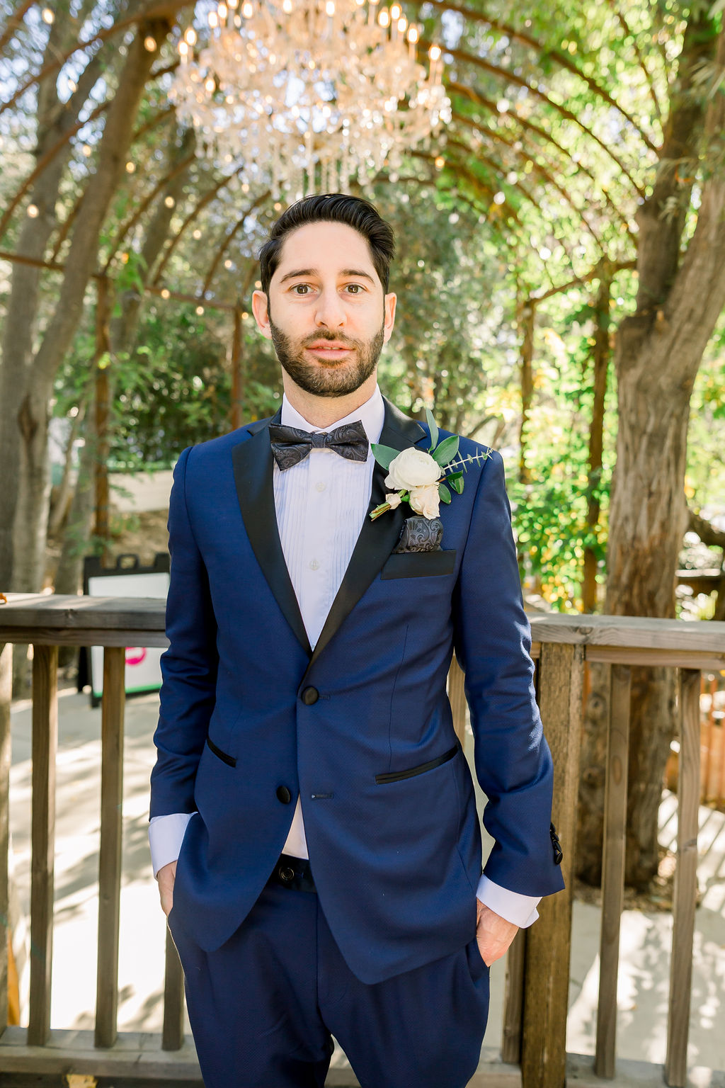 groom with paisley detail bowtie and blue tuxedo
