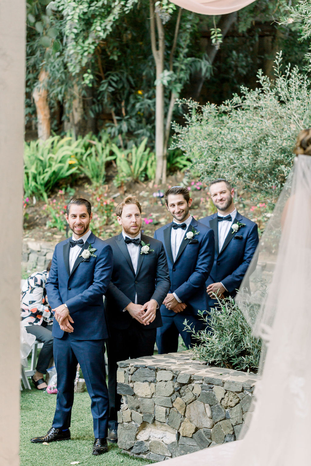 groomsmen in blue suits stand during wedding ceremony at Calamigos Ranch