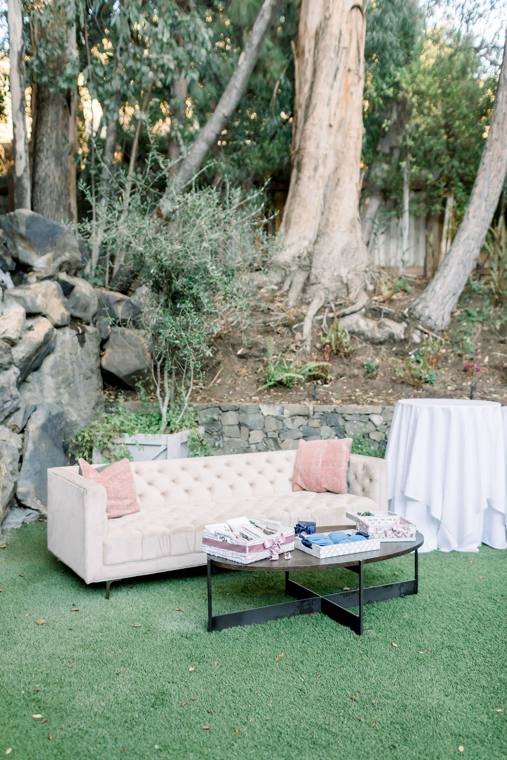 beige tufted couch with pink throw pillows creates lounge area at wedding at Calamigos Ranch