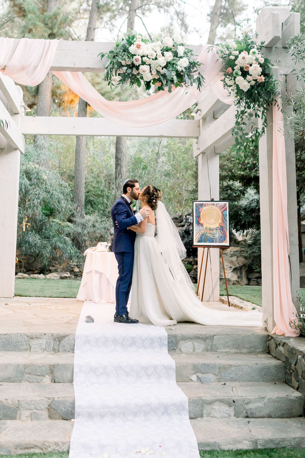 bride and groom kiss during romantic and glamorous wedding ceremony at Calamigos Ranch