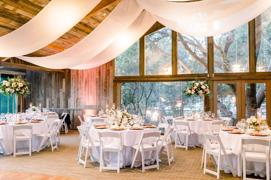 romantic and glamorous wedding reception at the Redwood Room at Calamigos Ranch with pink napkins and florals