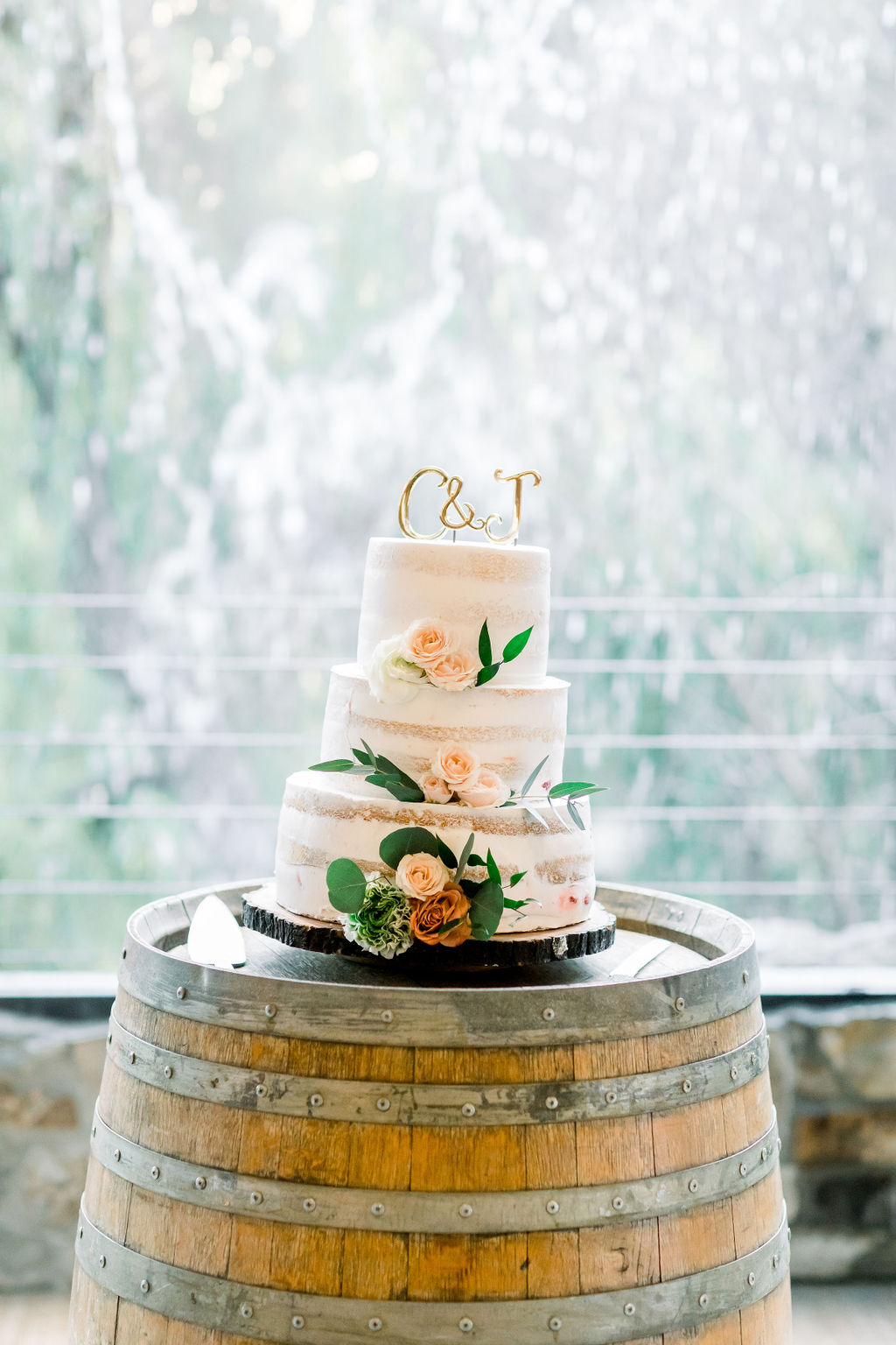 three tier naked wedding cake on wine barrel 