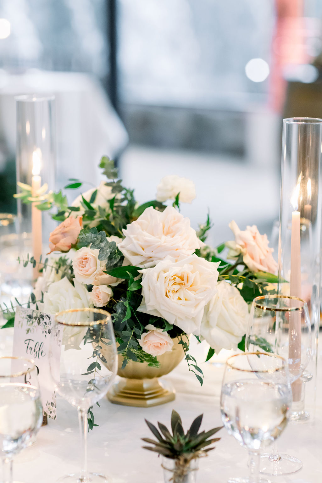 romantic and glamorous wedding reception at the Redwood Room at Calamigos Ranch with pink and white rose centerpiece in gold vase with pink taper candles