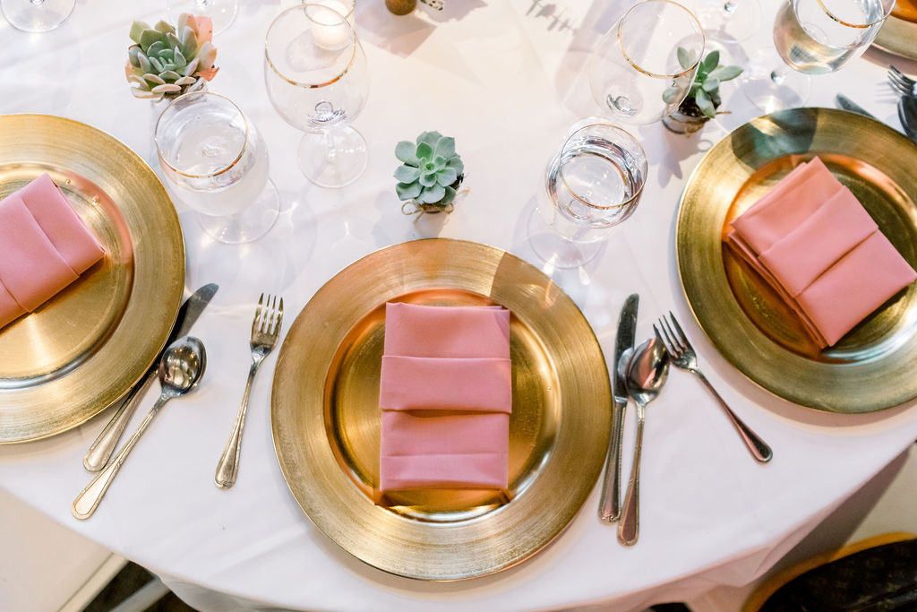 romantic and glamorous wedding reception at the Redwood Room at Calamigos Ranch with pink napkins and gold plate chargers