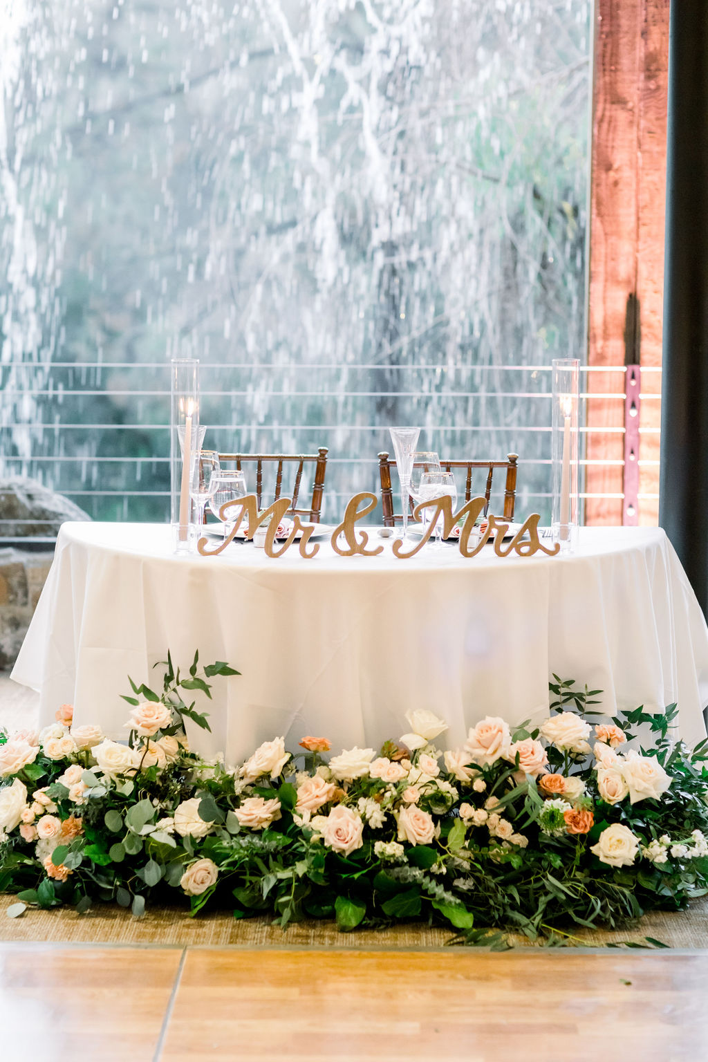 sweetheart table with gold mr and mrs sign and pink floral arrangement