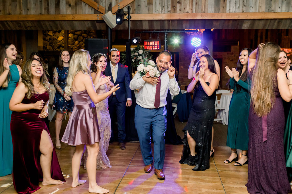 male guest catching bridal bouquet during toss