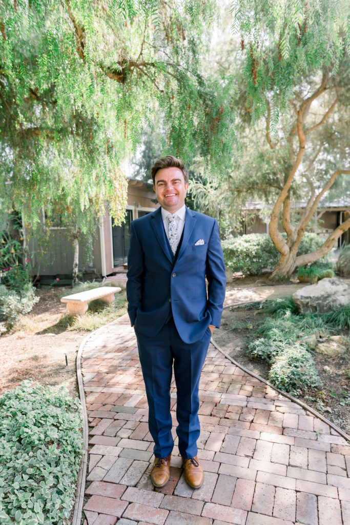 groom in blue suit with brown shoes and floral tie 