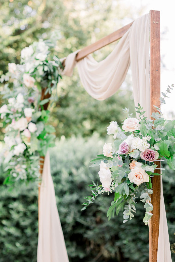charming wedding ceremony arch at Maravilla Gardens with soft pink chiffon drape and variety of pink florals with eucalyptus 