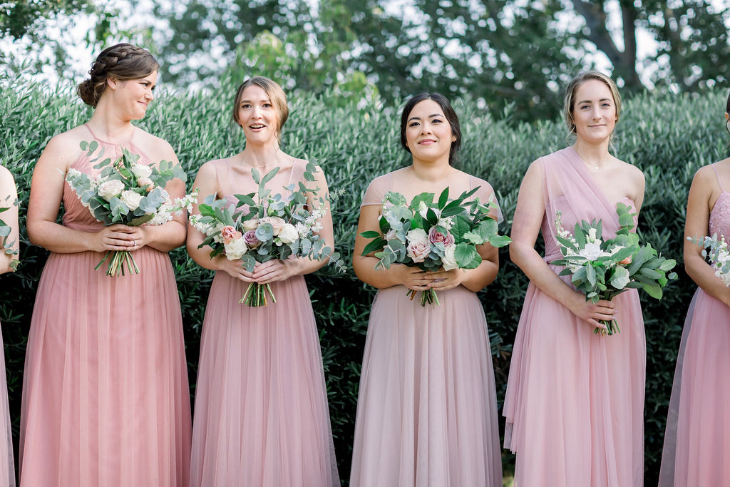 bridesmaids in mix and match pink dresses lined up 