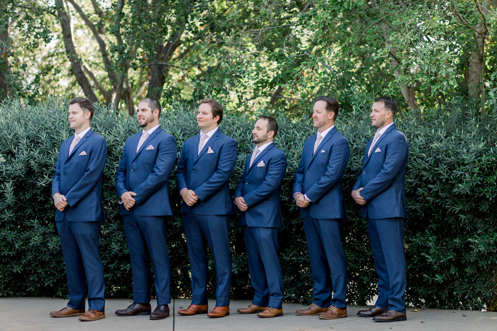 groomsmen in blue suits and pink ties