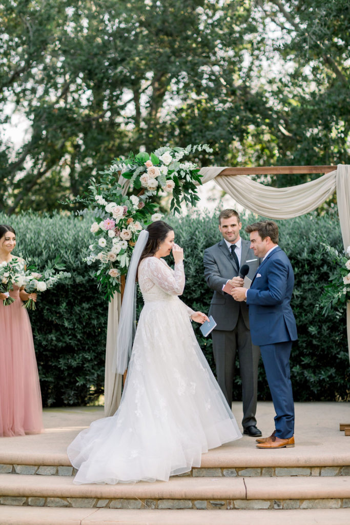 emotional bride listens to vows during charming wedding ceremony at Maravilla Gardens 