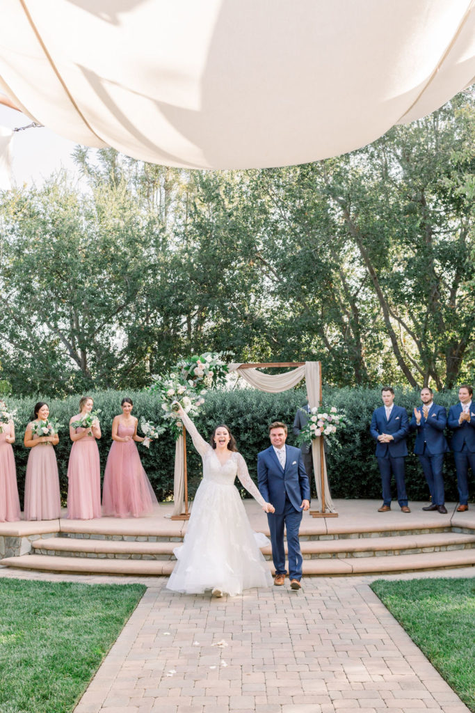 bride and groom recessional down the aisle during charming wedding ceremony at Maravilla Gardens 