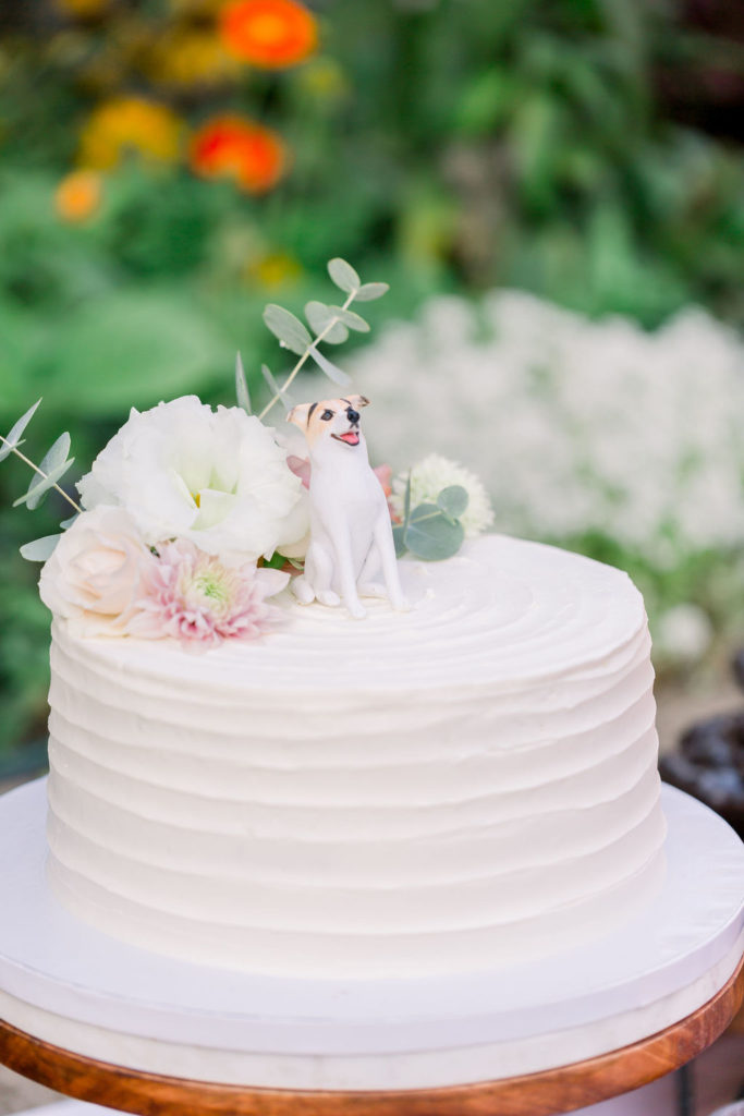 one tier wedding cake with figurine of couple's dog as cake topper