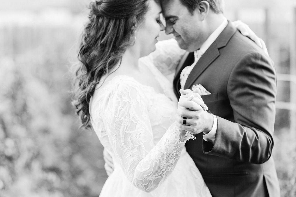 black and white photo of bride and groom dancing together