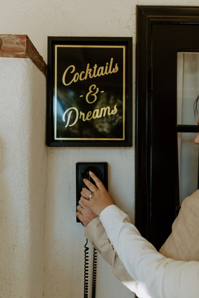 sign reading cocktails and dreams above vintage phone