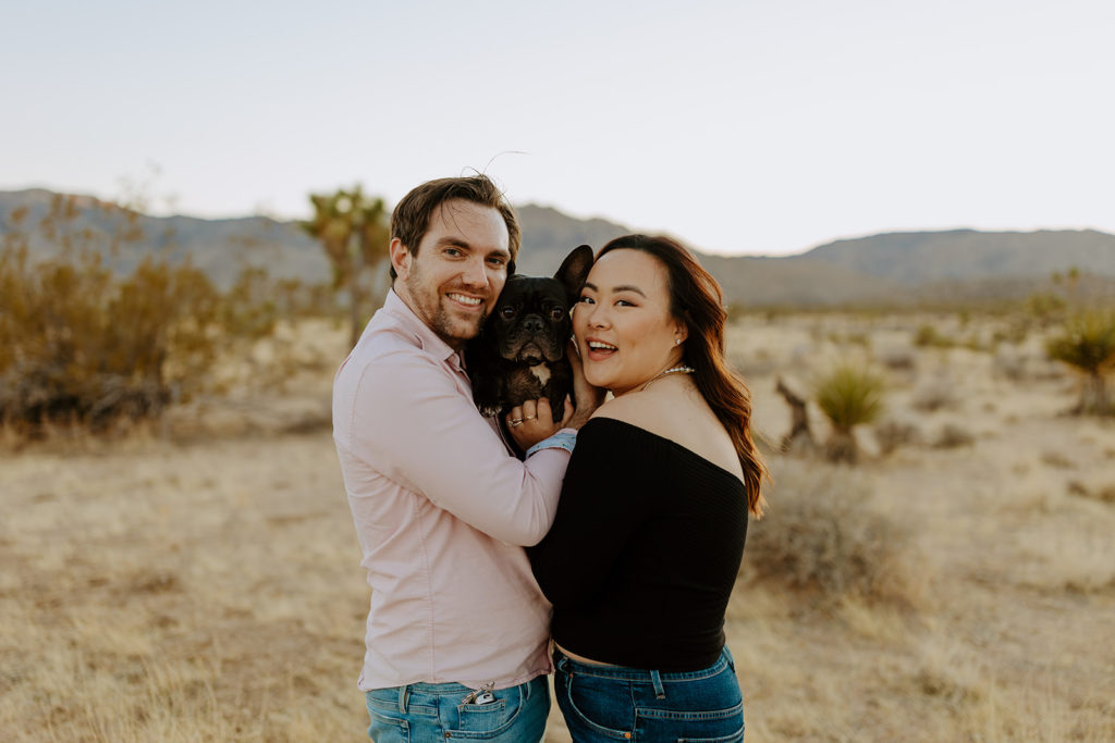 engaged couple pose in Palm Springs desert with their dog for their engagement photos