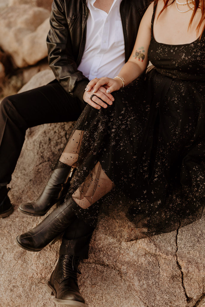 engaged couple in black outfits pose in Palm Spring desert for engagement photo session