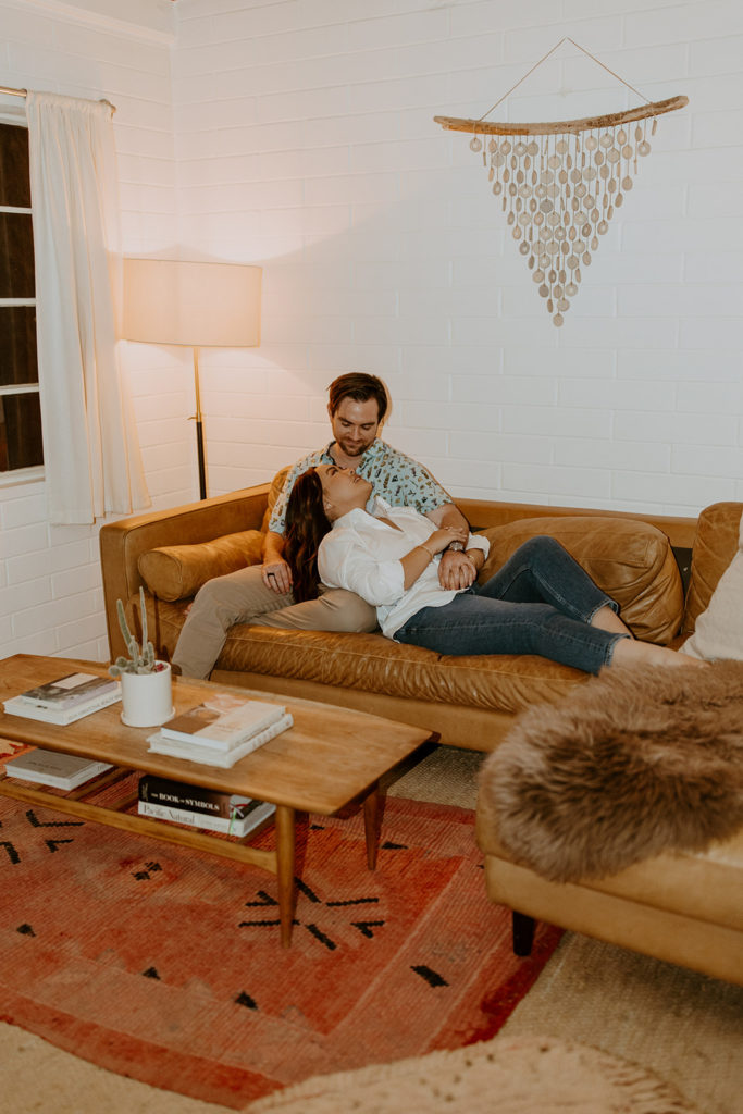 engaged couple sitting comfortably in air bnb during engagement photo session in Palm Springs