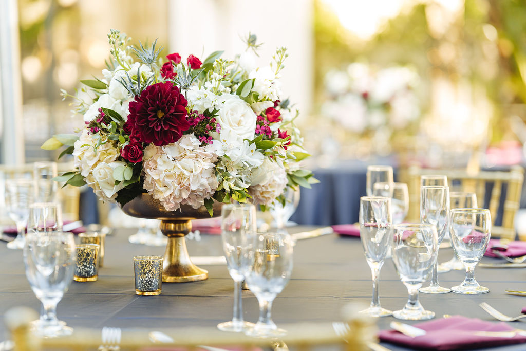 maroon and white floral arrangement in gold vase 