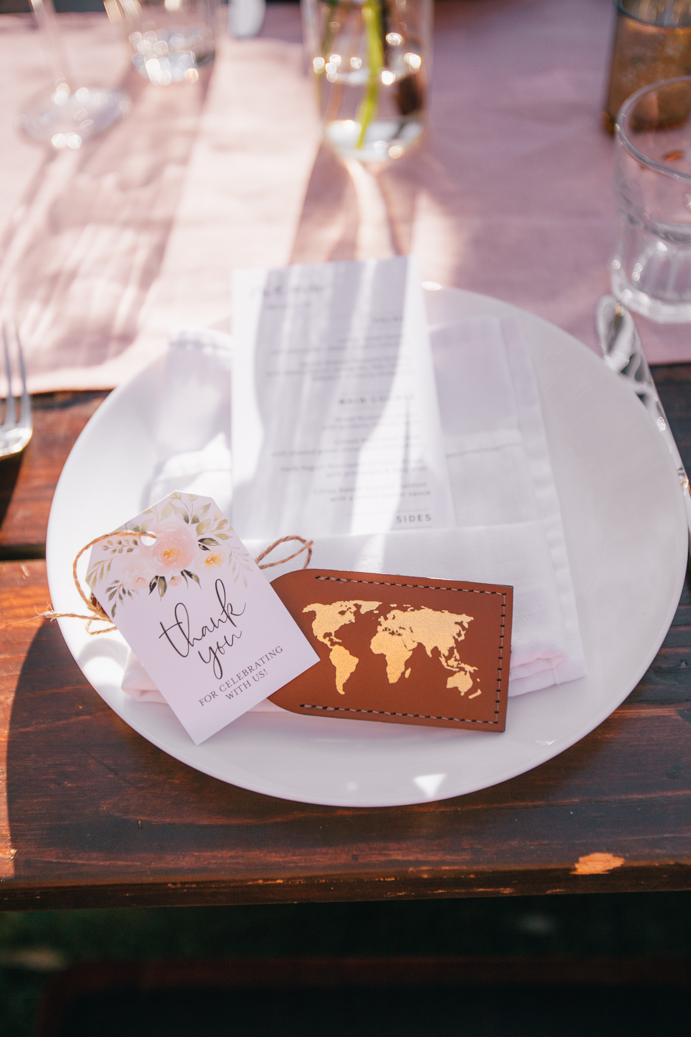 luggage tag on top of wedding reception menu for guest favor