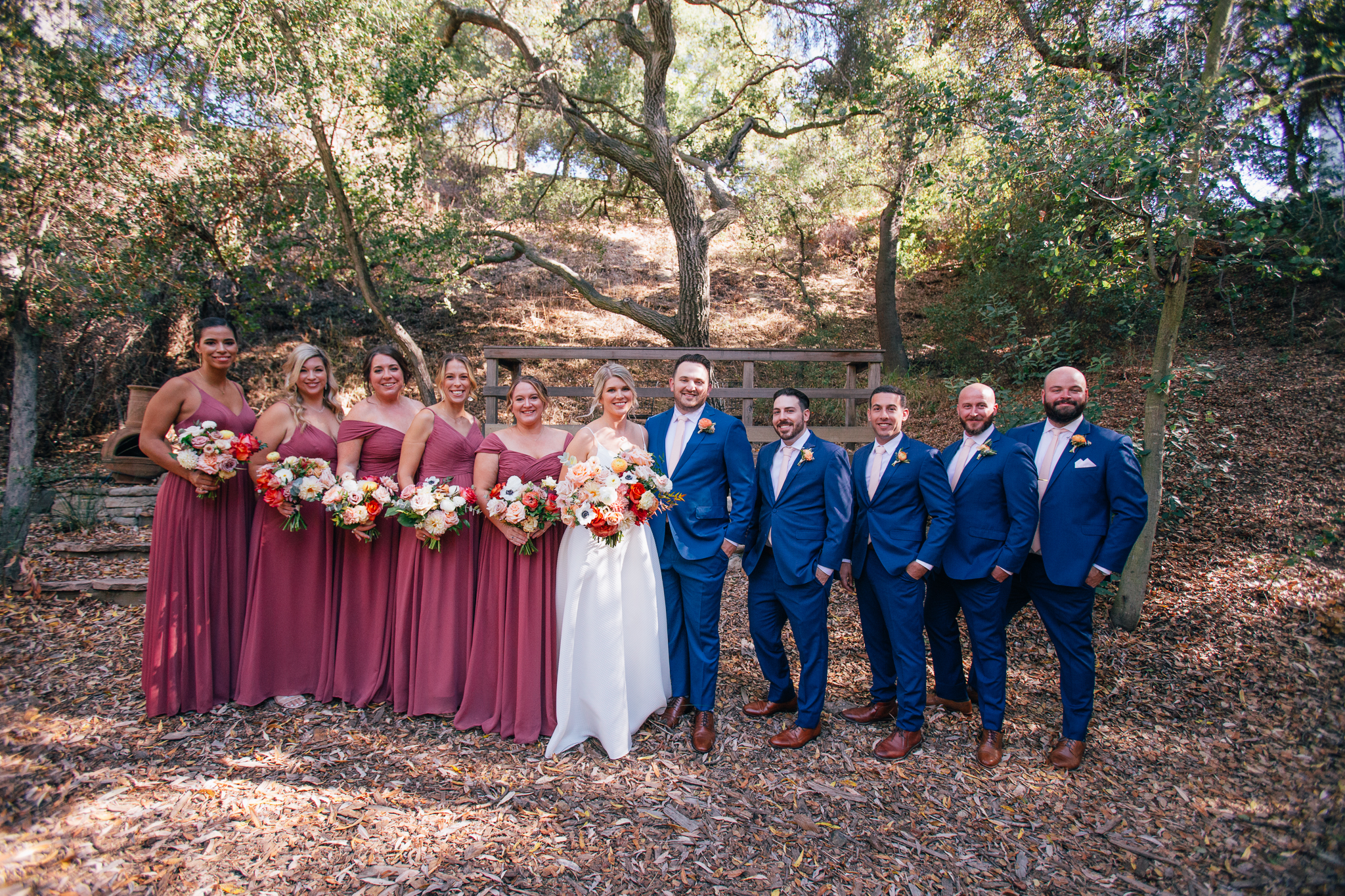 bride and groom stand with their wedding party before wedding ceremony
