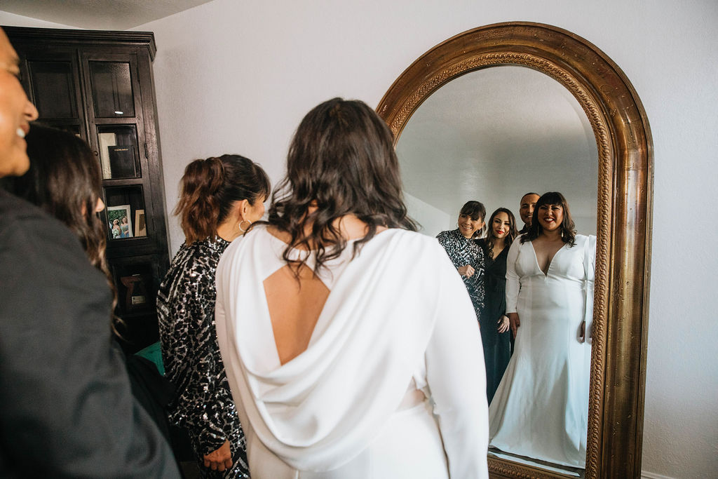 bride gets into long sleeve deep v neck with cowl back wedding dress