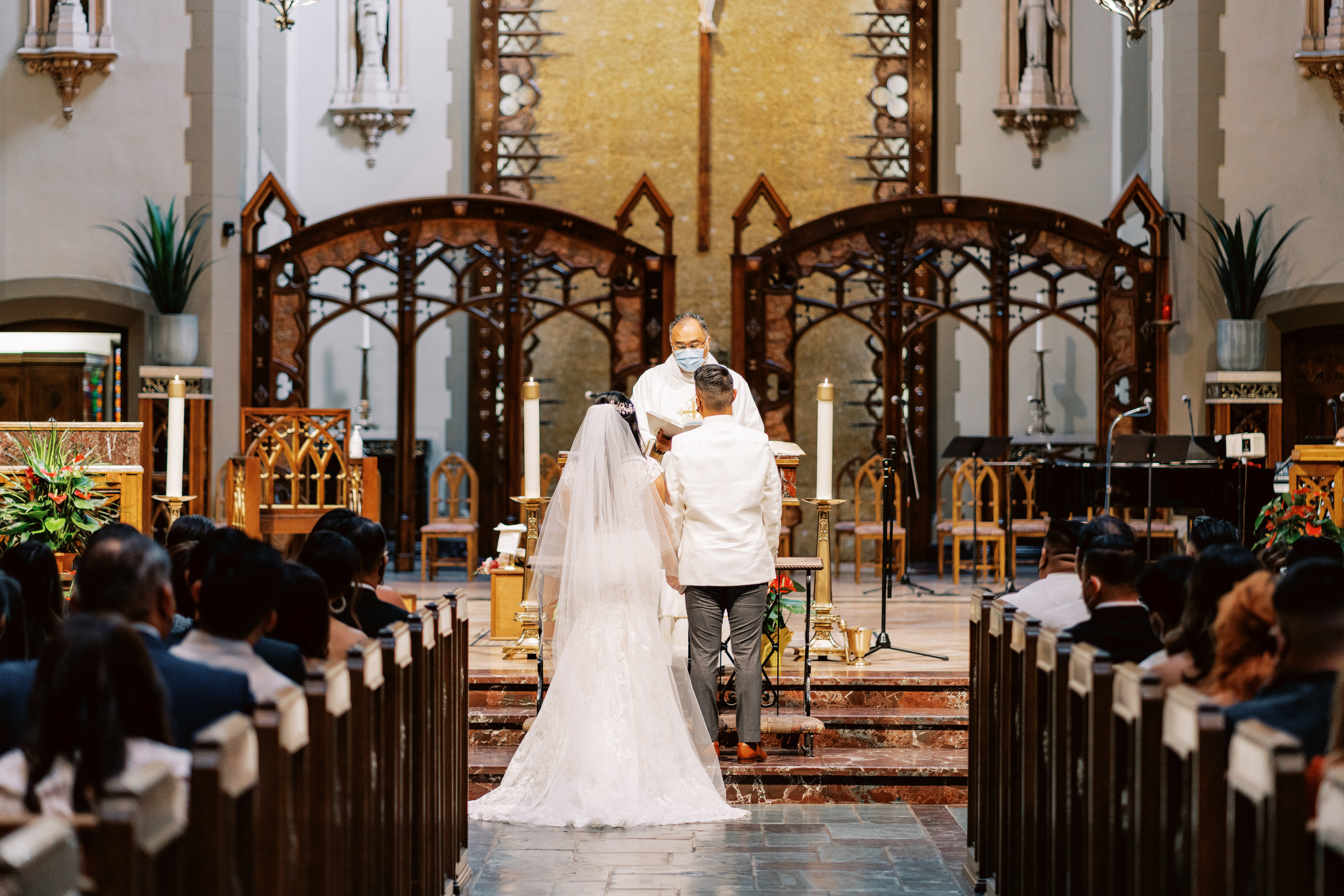 bride and groom stand together at altar during Catholic Church wedding ceremony