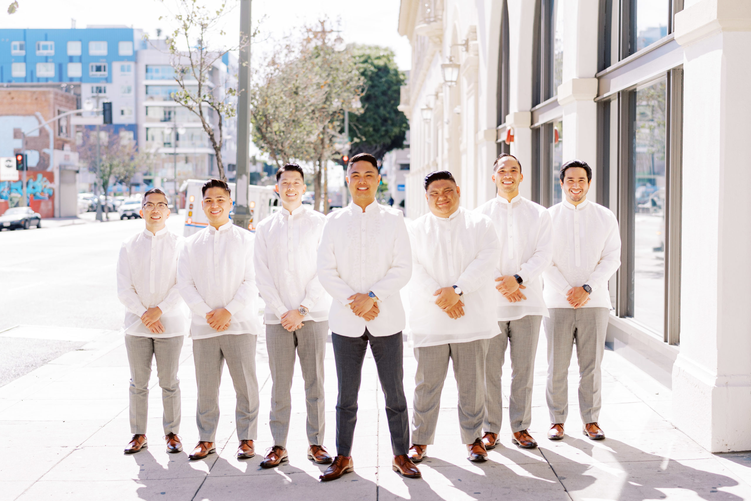 Groom with groomsmen in white traditional suits
