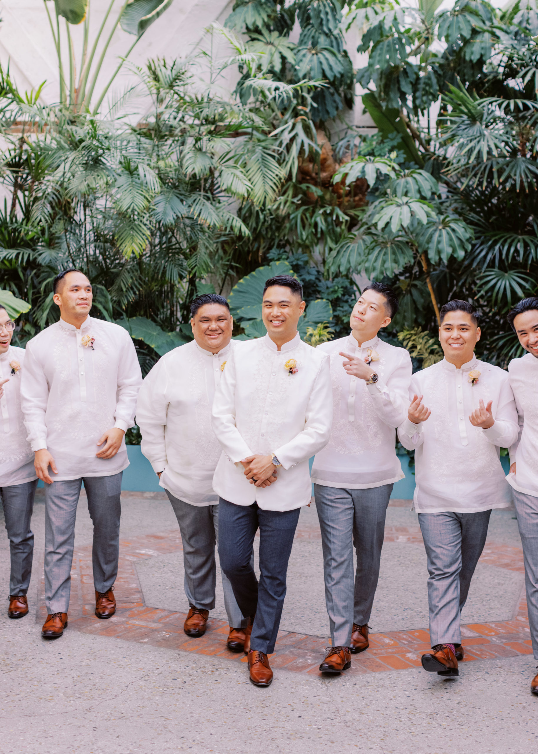groom in white wedding attire poses with groomsmen during cocktail hour at The Valentine DTLA 
